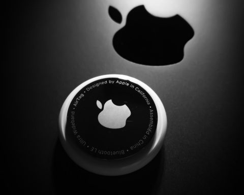 Schwarzes Logo auf einem runden, weißen Hintergrund mit Schatten eines Apfel-Logos.